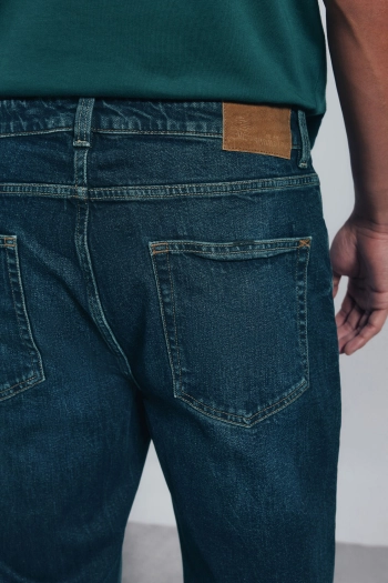 Джинсы кроя regular fit темного цвета с потертыми краями
